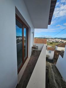 a balcony of a house with a table and chairs at Sunset Guesthouse - Costa Vicentina in Aljezur