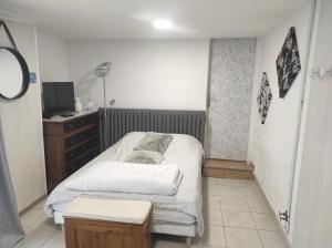 una piccola camera da letto con un letto e una cassettiera di Chambre entrée indépendante a Lodève