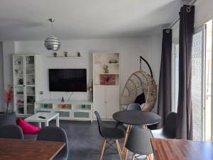 a living room with a tv and a table and chairs at Bright in Agaete