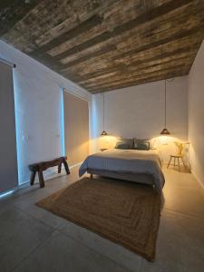 a bedroom with a bed and a wooden ceiling at Sunset Guesthouse - Costa Vicentina in Aljezur