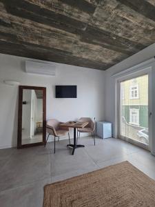 a living room with a table and chairs and a window at Sunset Guesthouse - Costa Vicentina in Aljezur