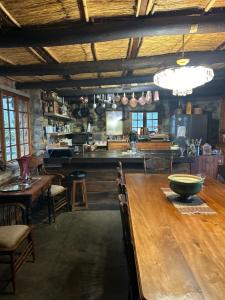 a dining room with a wooden table and a kitchen at Ouma se Plaashuis - Martine se kamer in Van Reenen +22 photos