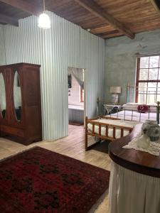 a bedroom with a bed and a table in a room at Ouma se Plaashuis - Martine se kamer in Van Reenen