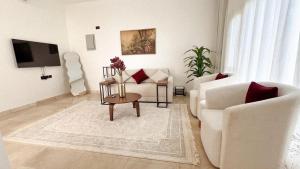 a living room with a white couch and a chair at Istrahtmas2 in Barka