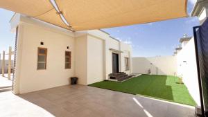 a large white house with a green lawn at Istrahtmas2 in Barka