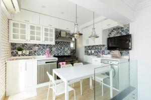 a kitchen with white cabinets and a table with chairs at White House in Madinaty
