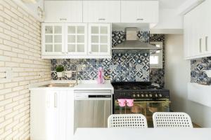 a kitchen with white cabinets and a stove top oven at White House in Madinaty +11 photos
