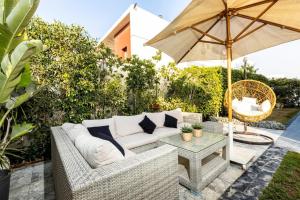 a patio with a white couch and an umbrella at White House in Madinaty