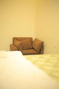a couch in the corner of a room with a bed at KIGALI QUEENs HOME AND APARTMENT in Kigali +22 photos