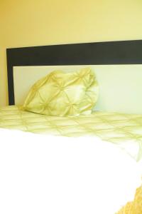 a white bed with a black headboard and a pillow at KIGALI QUEENs HOME AND APARTMENT in Kigali