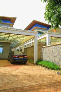 a car parked in front of a house at KIGALI QUEENs HOME AND APARTMENT in Kigali