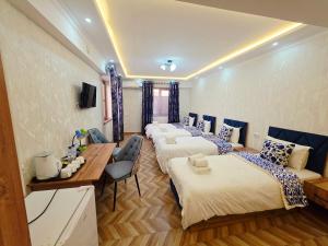een kamer met 4 bedden en een tafel en stoelen bij Samarkand Imron Hotel in Samarkand +123 foto's