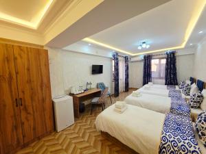 een hotelkamer met twee bedden en een bureau bij Samarkand Imron Hotel in Samarkand