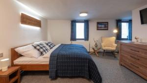 a bedroom with a bed and a dresser at Štepánka - Chalet & SPA in Benecko