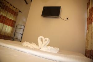 einen Haufen Handtücher auf einem Bett mit einem TV in der Unterkunft Rivinu Holiday Resort in Ella