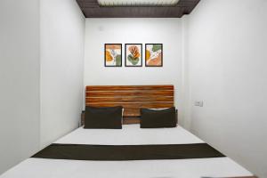 - une chambre avec un lit et trois photos sur le mur dans l'établissement Hotel O stay inn, à Shivāpur
