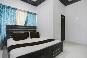 une chambre avec un grand lit avec des rideaux bleus dans l'établissement Hotel O stay inn, à Shivāpur 21 autres photos