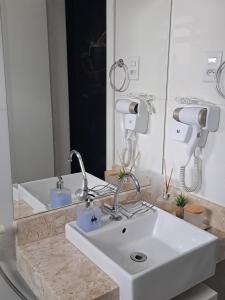 un bagno con un lavandino bianco e uno specchio di Hospedagem Altas da Quitéria Suíte 02 a Catas Altas Altre 35 foto