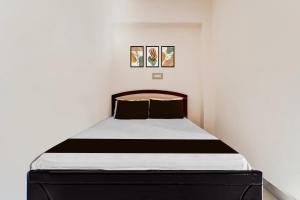 a bedroom with a bed with a black and white mattress at Hotel O by OYO Hill Top Hotel in Vānivilāsa Puram +21 photos