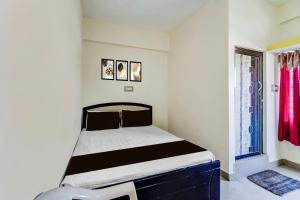a small bedroom with a bed and a window at Hotel O by OYO Hill Top Hotel in Vānivilāsa Puram