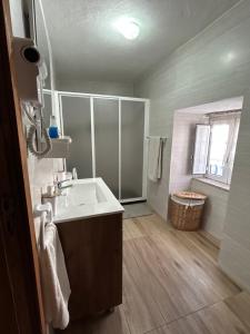a bathroom with a sink and a shower at Cantinho da Aldeia in Castedo