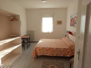 a bedroom with a bed and a table and a window at Garden Belvedere B&B in Nago-Torbole