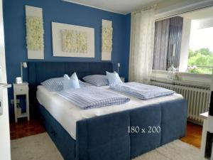 een blauwe slaapkamer met een bed met 2 kussens bij Harz-Fewo-Wolf in Bad Harzburg