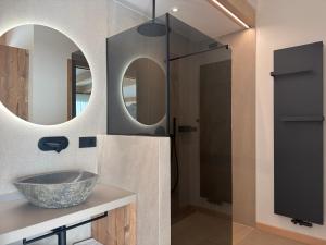 bagno con lavandino e 2 specchi di Liz Hotel & Apartments a Predazzo Altre 58 foto