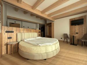 una camera da letto con un letto, un tavolo e delle sedie di Liz Hotel & Apartments a Predazzo