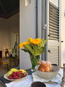 a table with a vase of flowers and a bowl of fruit at Dimora Delle Stelle - Design & Heritage in Bari +20 photos