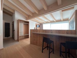 una cucina e un soggiorno con un bar e sedie di Liz Hotel & Apartments a Predazzo