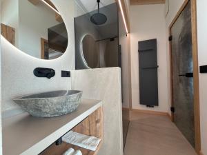 un bagno con un lavandino e uno specchio di Liz Hotel & Apartments a Predazzo