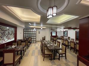 a dining room with long tables and chairs at Nascent Gardenia Residence in Dhaka