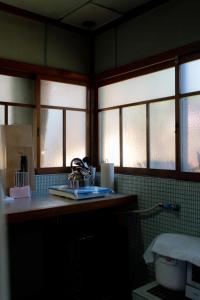 un bagno con lavandino e due finestre di Kashiwaya Inn a Nagiso Altre 28 foto