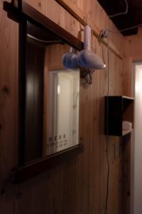 bagno con specchio e luce sul muro di Kashiwaya Inn a Nagiso