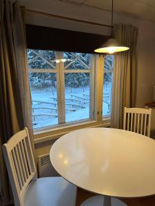 a white table and chairs in front of a window at Guest cabin, Haukipudas, sauna and free parking in Haukipudas