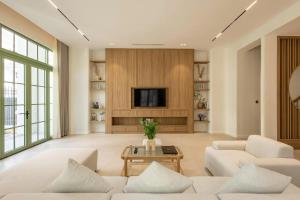 een woonkamer met witte meubels en een televisie bij Green Villas Tropical Phú Quốc in Phu Quoc