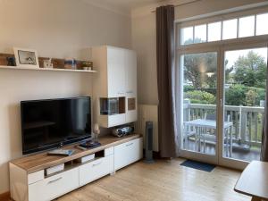 ein Wohnzimmer mit einem großen TV und einem Balkon in der Unterkunft Villa Glück Auf - 08-05 in Kühlungsborn + 6 Fotos