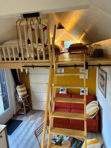a bunk bed in a room with a ladder at Location en bordure du Trieux in Plourivo