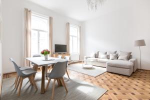 - un salon avec une table et un canapé dans l'établissement HeyMi Apartments in City Center, à Vienne