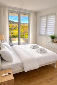 ein weißes Schlafzimmer mit einem großen Bett und einem Fenster in der Unterkunft Green panorama Vrdnik in Vrdnik + 30 Fotos