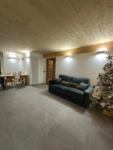 ein Wohnzimmer mit einer Couch und einem Weihnachtsbaum in der Unterkunft Maison ValGià in Champoluc