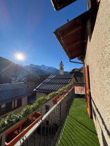 einen Balkon mit Pflanzen und Blick auf ein Gebäude in der Unterkunft Il GIGLIO in Ponte di Legno
