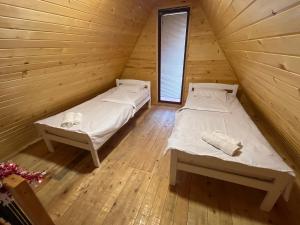 a bedroom with two beds in a wooden cabin at Vikendica SD - Donja Krćina in Ugljevik