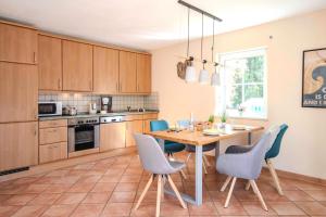une cuisine avec une table en bois et des chaises ainsi qu'une salle à manger dans l'établissement Weststrandläufer, à Wieck
