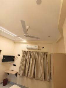 a room with a ceiling fan and a curtain at C K Residency in Cochin