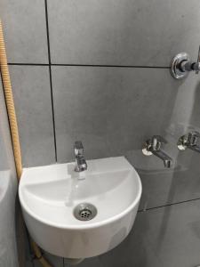 a white sink in a bathroom with two faucets at C K Residency in Cochin +2 photos