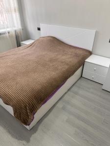 ein Schlafzimmer mit einem Bett mit einer braunen Decke in der Unterkunft Sweet Home in Wanadsor