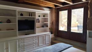 a living room with a tv and a window at Casa Vilar de Flores in Ourense