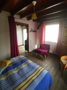 a bedroom with a bed and a purple chair at LES GITES D'AVEZE Volcan, Sancy, Bourboule in Avèze
